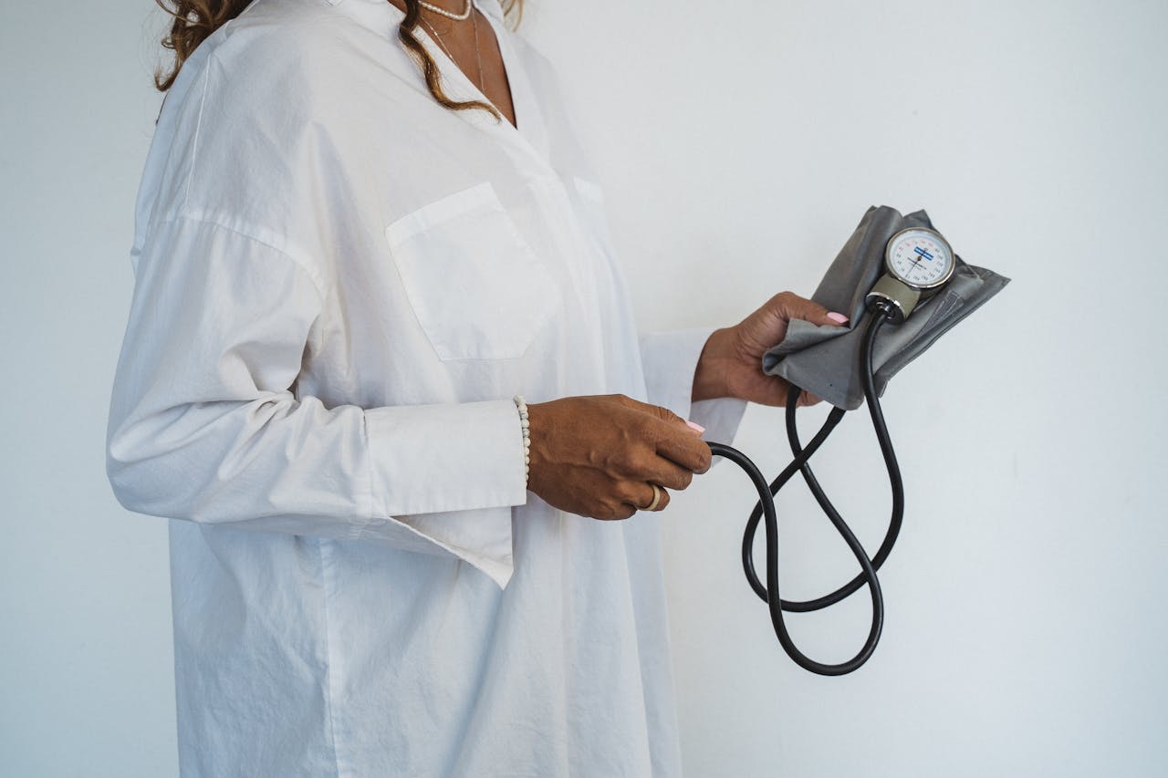 Home A healthcare professional in white holding a sphygmomanometer, demonstrating medical care.
